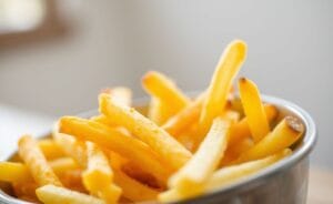 Bowl com batatas fritas douradas e crocantes, preparadas na air fryer, apresentando uma textura perfeita.